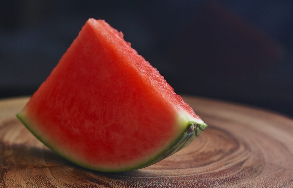 Slice of red watermelon on a wooden board