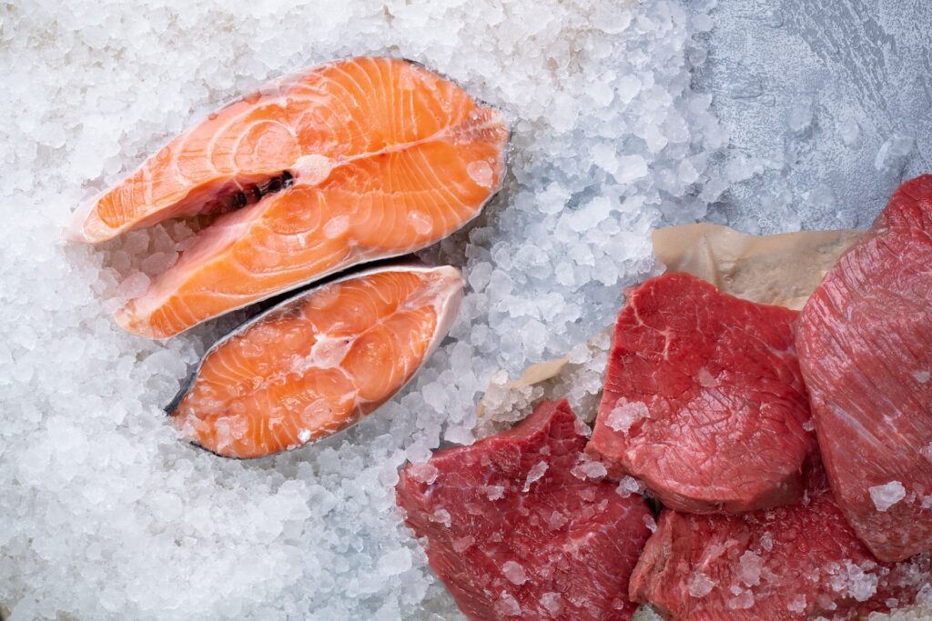 Raw salmon steaks and red meat on ice